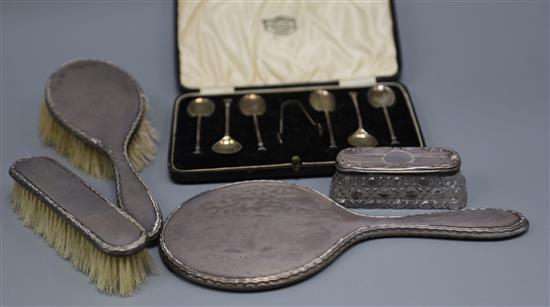 A set of six George V silver coffee spoons, a three piece dressing table set and a silver topped box